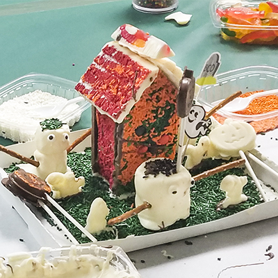 Halloween chocolate haunted house with marshmallow and pretzel figures